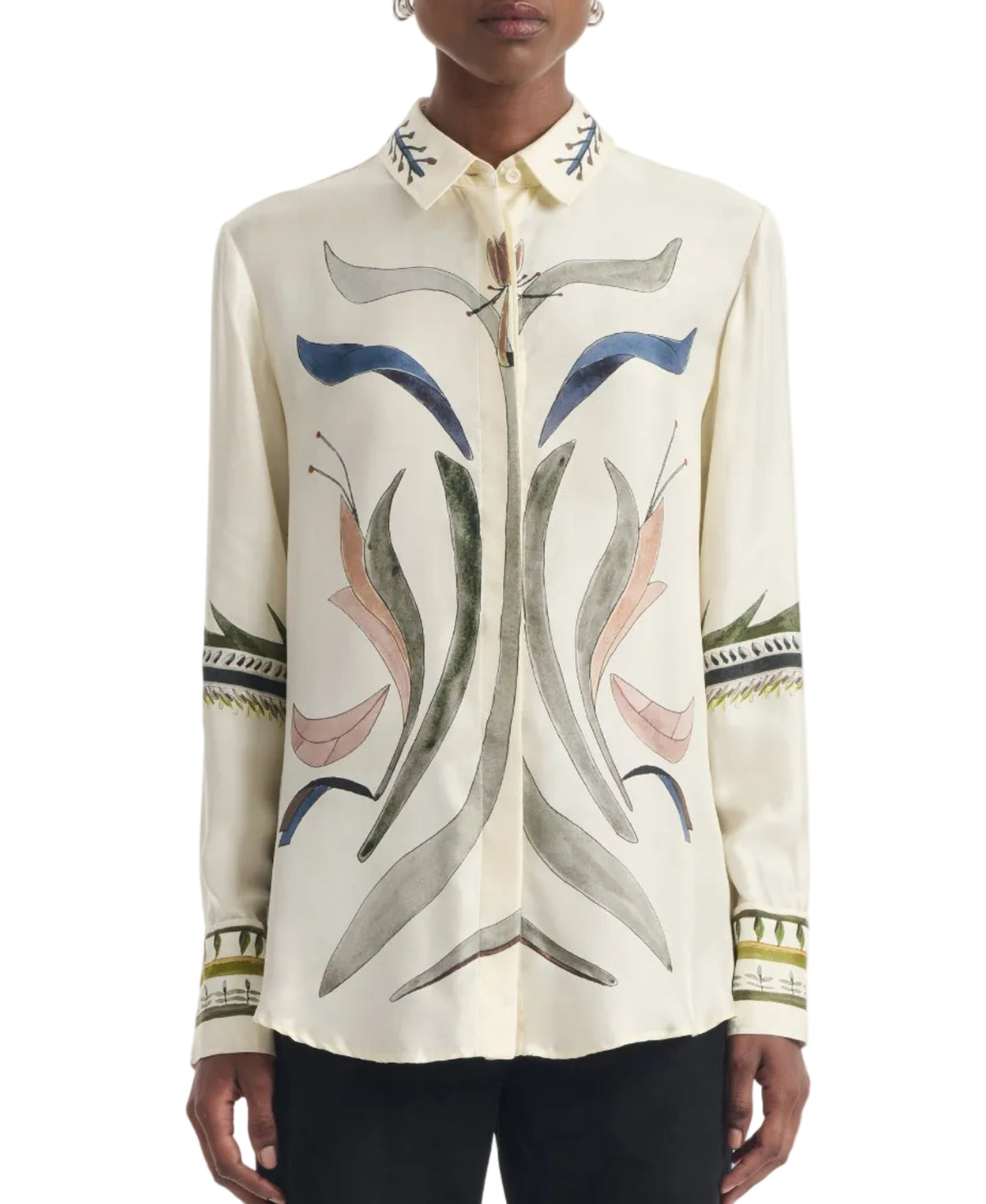 A person wearing the Altuzarra Chika Top—a cream-colored silk blouse featuring abstract multicolored patterns and embroidery on the front, collar, and sleeves, with a relaxed silhouette and a concealed button closure.