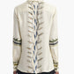 Person wearing the Altuzarra Chika Top, a cream-colored silk piece adorned with intricate geometric and wavy patterns down the back and along the sleeves, featuring a relaxed silhouette and a concealed button closure for an elevated finish.