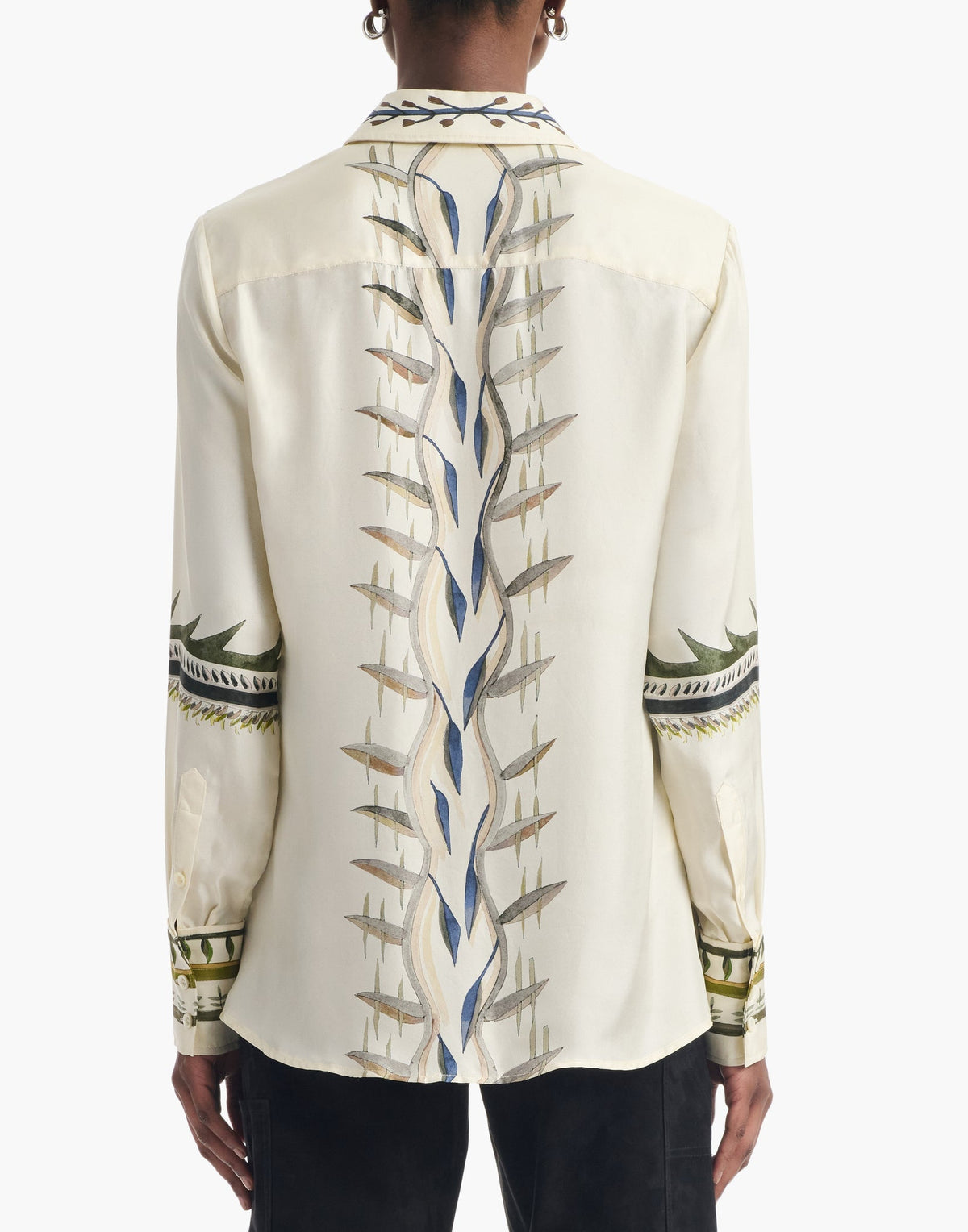 Person wearing the Altuzarra Chika Top, a cream-colored silk piece adorned with intricate geometric and wavy patterns down the back and along the sleeves, featuring a relaxed silhouette and a concealed button closure for an elevated finish.