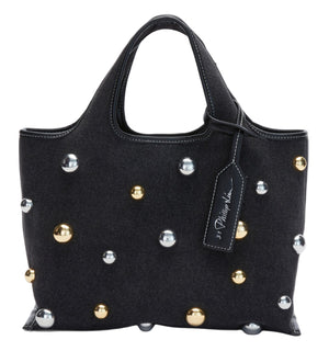 The 3.1 Phillip Lim Washed Denim Mini Market Tote is a small handbag with short handles, adorned with gold and silver spherical studs and finished with a visible designer tag on one handle.