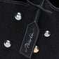 Close-up of a Washed Denim Mini Market Tote by 3.1 Phillip Lim, featuring silver and gold dome studs and a black tag with white branding.