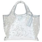 The Mesh Sequin Mini Market Tote by 3.1 Phillip Lim features silver sequins, short handles, and a matching tag, creating a sparkling accessory against a white backdrop.