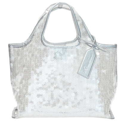 The Mesh Sequin Mini Market Tote by 3.1 Phillip Lim features silver sequins, short handles, and a matching tag, creating a sparkling accessory against a white backdrop.