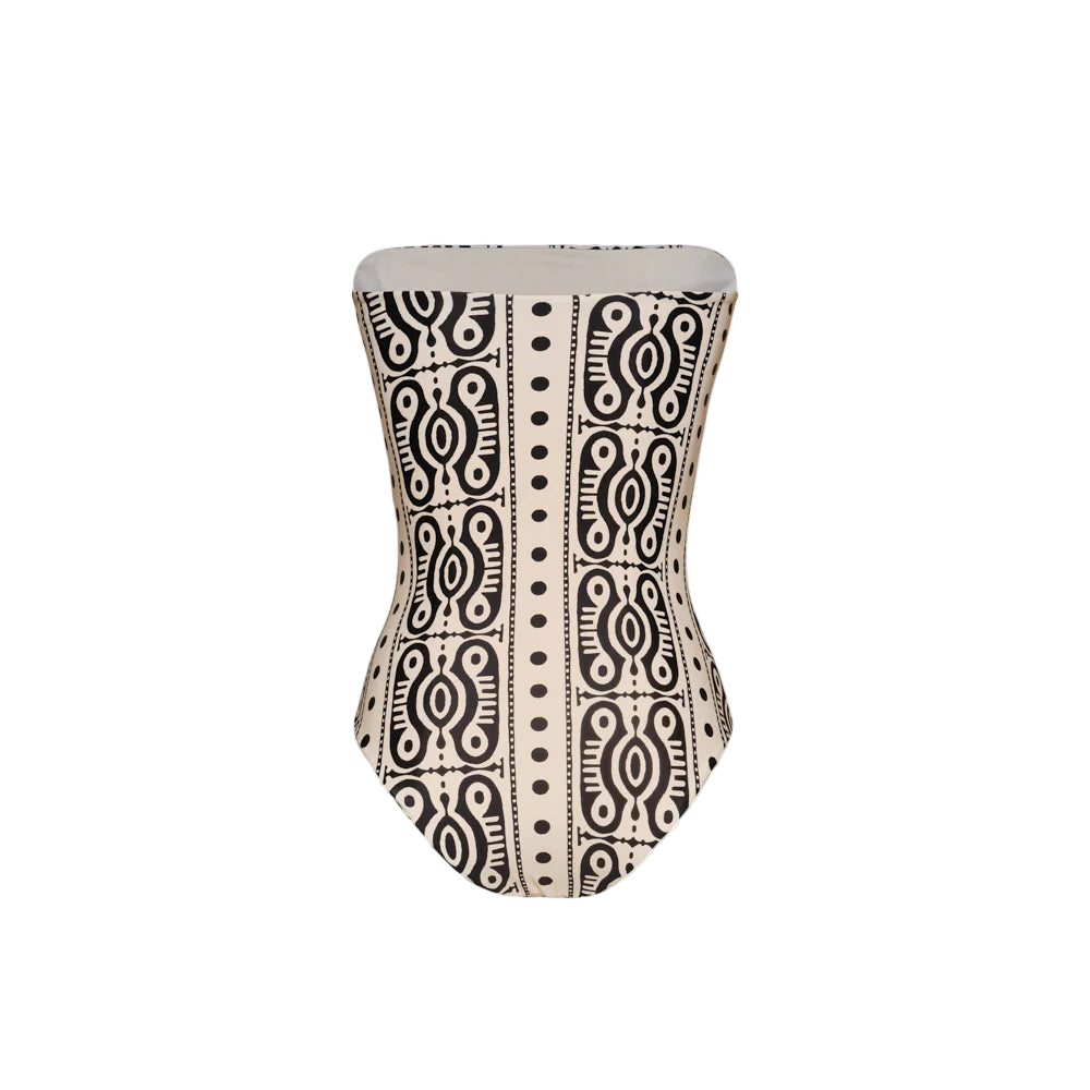 The Tribal Alta Mar One Piece by Johanna Ortiz is a strapless swimsuit featuring a striking black and white geometric and abstract pattern, ideal for a chic resort look.