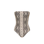 The Johanna Ortiz Tribal Alta Mar One Piece is a strapless swimsuit featuring a bold black geometric pattern on beige, evoking chic resort style and displayed against a plain white background.
