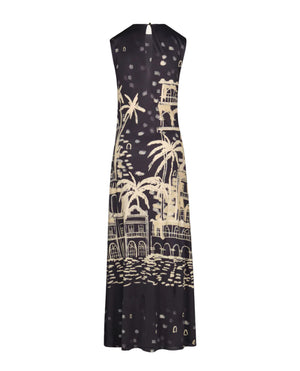 The Cardinal Direction Ankle Dress by Johanna Ortiz is a sleeveless black shiny jersey dress with a beige graphic print of palm trees and buildings, shown on a plain white background.
