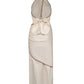 The Centro Del Cielo Ankle Dress by Johanna Ortiz is a beige halter-neck midi with an open back, large bow detail, brown trim, and asymmetric draping—a quiet luxury piece ideal for special occasions.