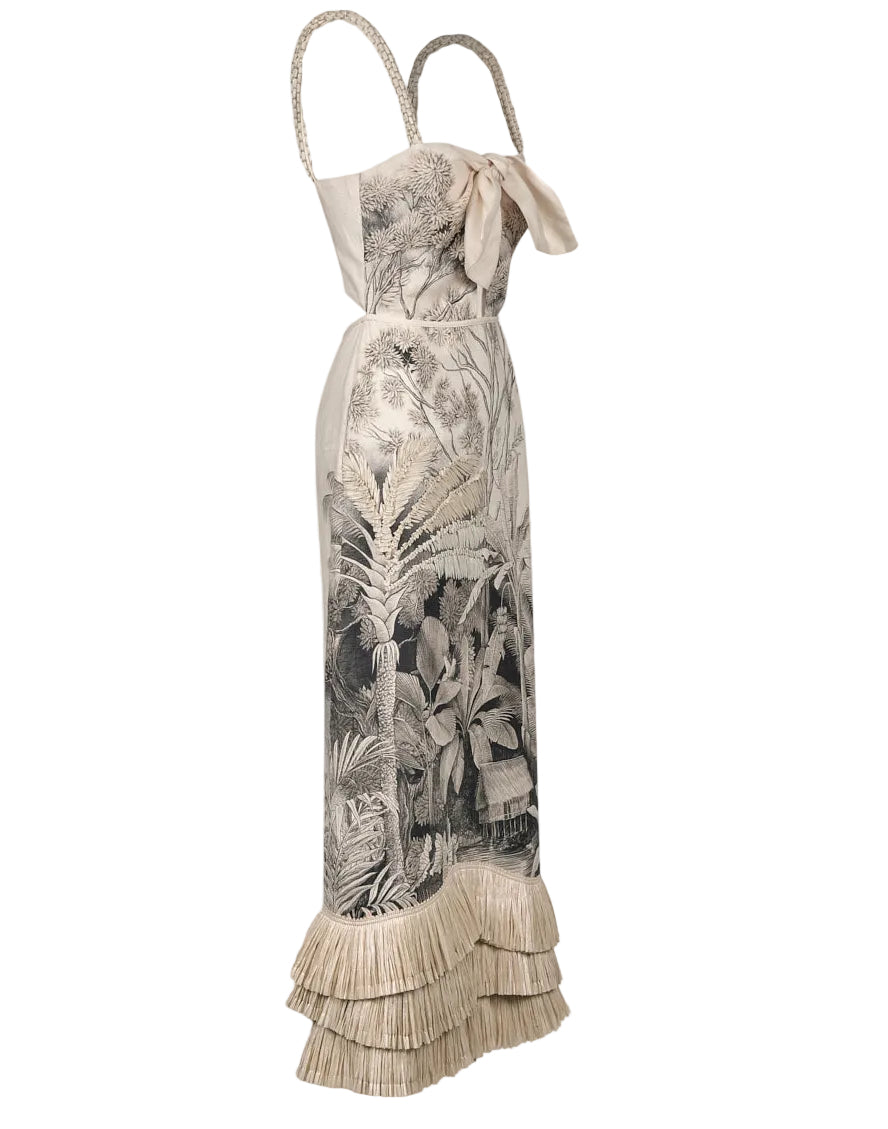 The Invictus Ankle Dress by Johanna Ortiz is a sleeveless linen dress featuring a botanical print, ribbon detail at the bust, braided straps, and a layered fringe hem for an elegant, breezy look.