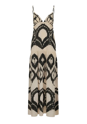 The Zea Palm Maxi Dress by Johanna Ortiz is a sleeveless, cream-colored dress featuring an empire waist, thin adjustable straps, and a striking black abstract pattern.