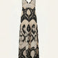 The Zea Palm Maxi Dress by Johanna Ortiz is a sleeveless beige cotton poplin maxi dress with a black abstract pattern, thin adjustable straps, and an elegant empire waist, shown on a plain background.