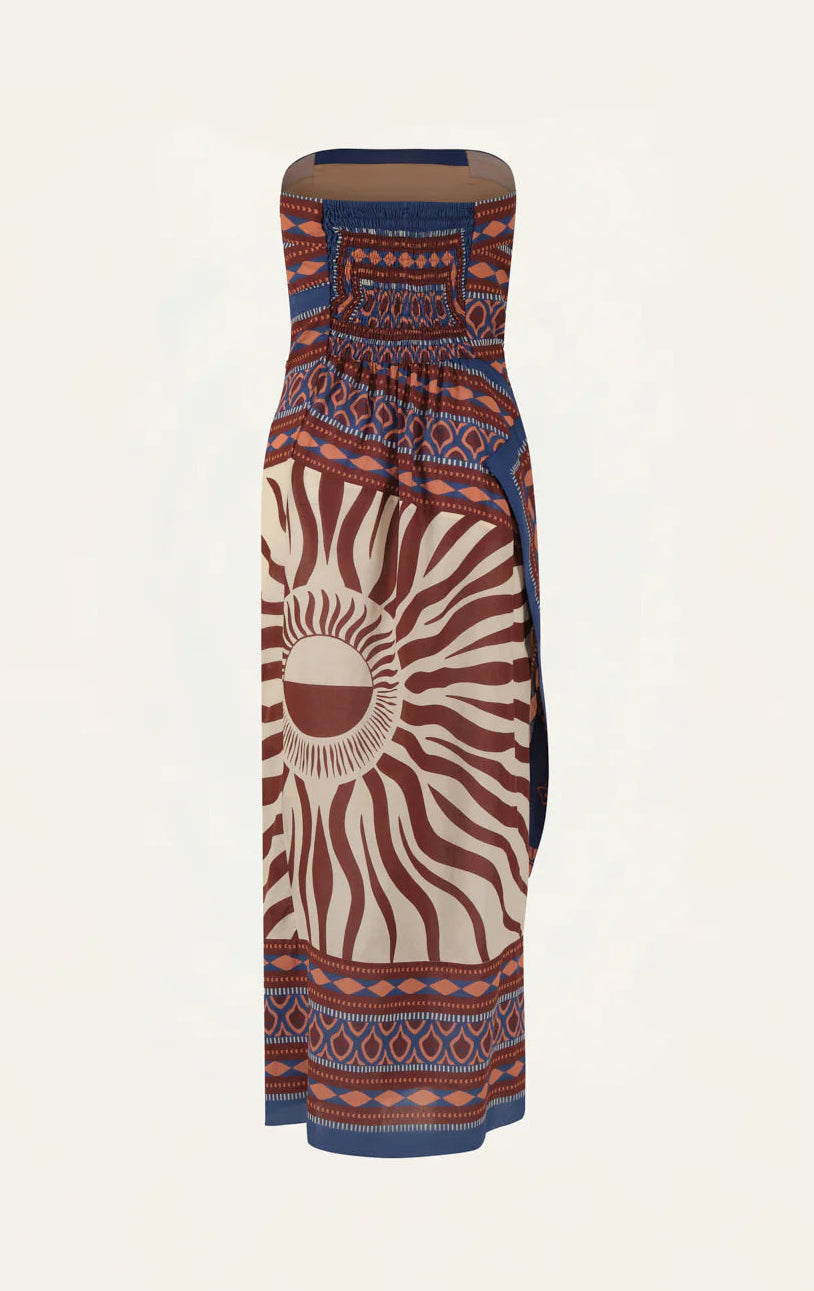 The Johanna Ortiz Paraiso Agreste Ankle Dress features a strapless neckline and geometric sunburst pattern in brown, cream, and blue. With its fitted bodice and straight silhouette, it’s perfect for stylish summer soirées.
