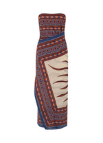 The Paraiso Agreste Ankle Dress by Johanna Ortiz features a bold blue, orange, and cream geometric wave pattern and a striking strapless neckline—perfect for summer soirées.