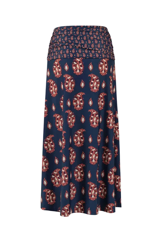The Under The Sun Ankle Skirt by Johanna Ortiz is a long navy blue maxi skirt featuring a red and white paisley JO print and a comfortable smocked waistband.