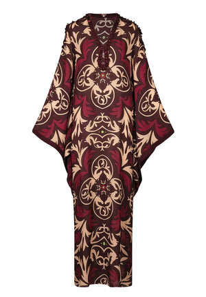 Introducing the One Palm Only Tunic Dress by Johanna Ortiz—a relaxed, floor-length silhouette with wide sleeves, adorned in an intricate maroon, beige, and brown pattern. This piece features a v-neckline embellished with hand-applied beaded detailing for a distinctive decorative touch.