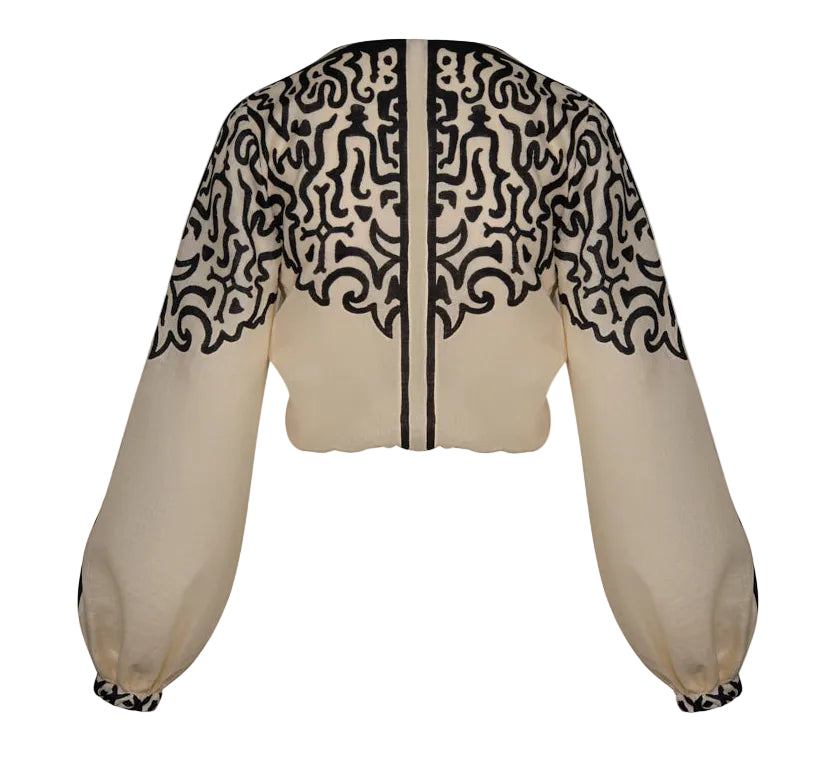 Johanna Ortiz Gentle Burn Top: cropped beige blouse with a black Ancient Markings print on the shoulders and sleeves, featuring a black center front placket.