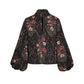 Back view of the Johanna Ortiz Jacquard Intricate Islands Top, a long-sleeved black blouse with a red and pink botanical motif, a high neckline, and a keyhole opening.