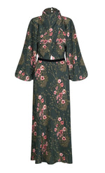 Johanna Ortiz Golden Vibe Dress, a long-sleeved, high-neck midi dress in a dark green botanical print with a black velvet waistband and voluminous sleeves.