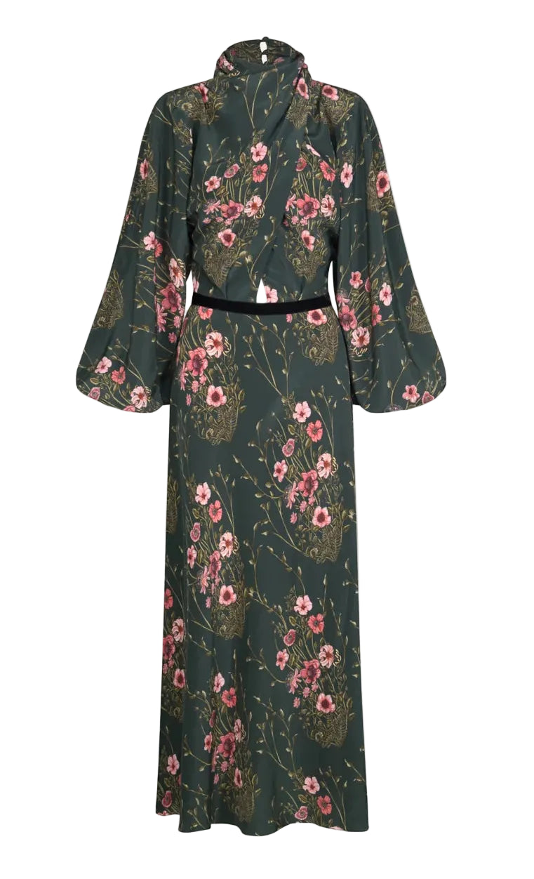 Johanna Ortiz Golden Vibe Dress, a long-sleeved, high-neck midi dress in a dark green botanical print with a black velvet waistband and voluminous sleeves.