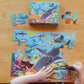 A child joyfully assembles the Eeboo Sharks & Friends 20pc Puzzle, featuring vibrant illustrations of sea creatures. In the background, the box hints at this engaging preschool puzzle adventure.