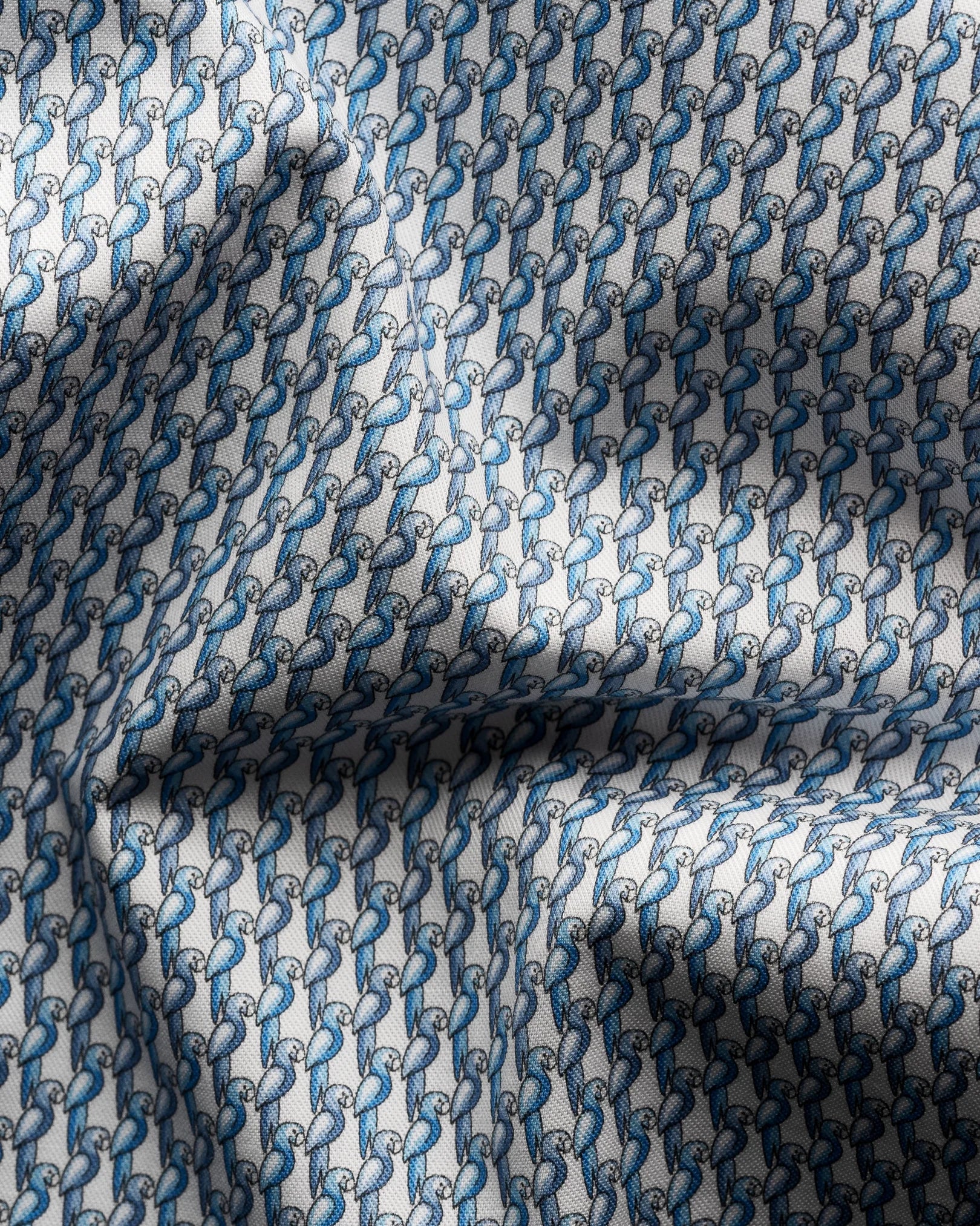 Close-up of Eton's Cut Away Slim Signature Twill Parrot Shirt, showcasing a repeating pattern of interlocking blue and gray shapes on white. Crafted from extra-long staple cotton for a wrinkle-free finish.