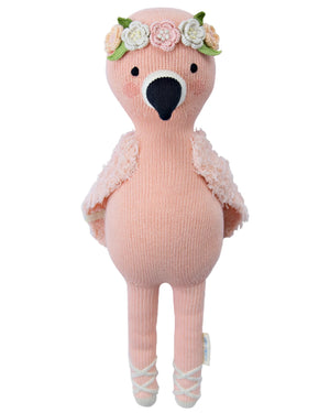 Penelope the Flamingo - Regular 20" by Cuddle + Kind is a pink stuffed flamingo with a tropical flower crown, textured wings, and white ballet shoes. Perfect for birthdays, it brings joy while helping provide 1 million meals to those in need.
