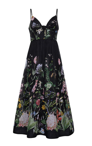 The Pero Midi Dress by Cara Cara is a sleeveless black fit-and-flare midi dress with adjustable spaghetti straps and a vibrant floral print on the skirt and bodice.