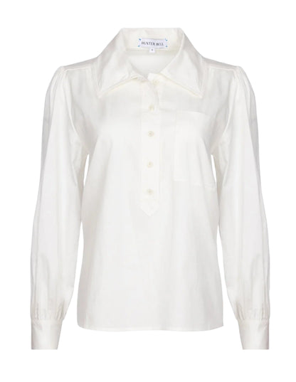 The Hunter Bell Phoenix Shirt by Hunter Bell NYC is a versatile white blouse with long sleeves, a tailored collar, and a button-up front.