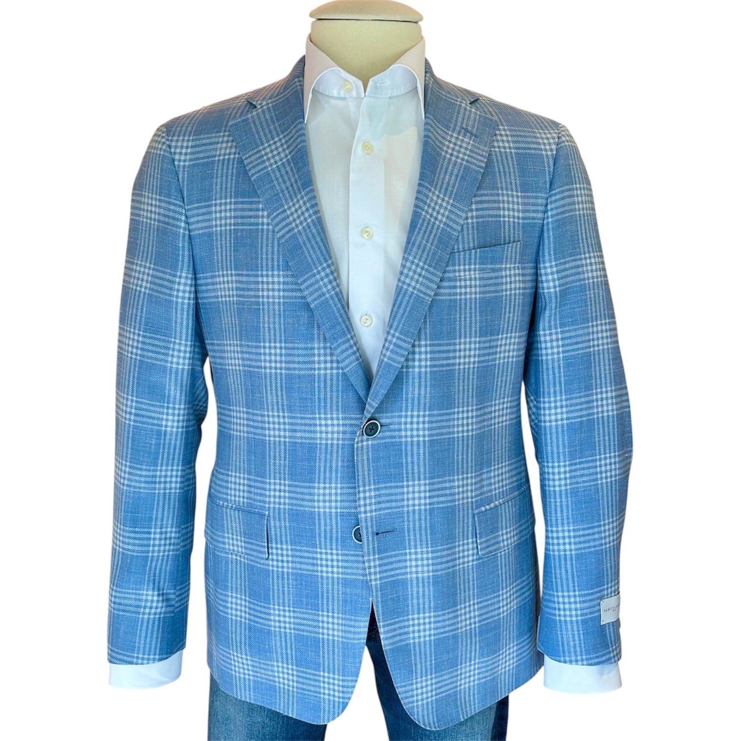 The Bennet Contemporary Fit Blazer by Samuelsohn features blue and white plaid, two buttons, and hand-tailoring. Shown on a mannequin over a white shirt with blue jeans.