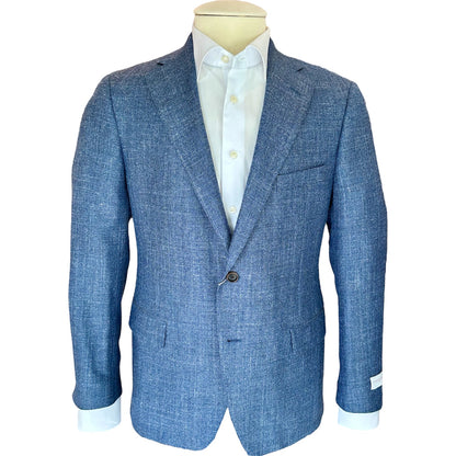 The Samuelsohn Bennet Natural Chambray Blazer features notch lapels, a two-button front, and flap pockets, shown over a white shirt—an ideal luxury choice for menswear enthusiasts.