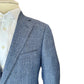 Close-up of the Bennet Natural Chambray Blazer by Samuelsohn, a luxury light blue textured blazer, displayed over a white dress shirt on a mannequin against a white background.