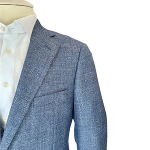 Close-up of the Bennet Natural Chambray Blazer by Samuelsohn, a luxury light blue textured blazer, displayed over a white dress shirt on a mannequin against a white background.
