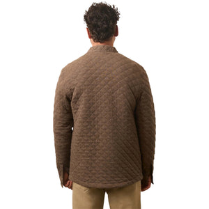 A man faces away from the camera, dressed in Faherty’s Epic Quilted Fleece in brown with beige pants, set against a white background.