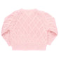 The Pink Chicken Baby Girls' Katrina Sweater, a charming pink cable-knit garment with a diamond lattice pattern, features a delicate glitter button closure shown from the back.