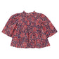 The Girls’ Jaipur Top by Pink Chicken features a red and navy paisley pattern with long bell sleeves, a round neckline, and navy glitter buttons for an elegant touch. Its loose fit offers both comfort and effortless style.
