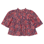 The Girls’ Jaipur Top by Pink Chicken features a red and navy paisley pattern with long bell sleeves, a round neckline, and navy glitter buttons for an elegant touch. Its loose fit offers both comfort and effortless style.