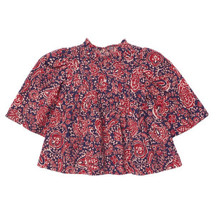 The Girls’ Jaipur Top by Pink Chicken features a red and navy paisley pattern with long bell sleeves, a round neckline, and navy glitter buttons for an elegant touch. Its loose fit offers both comfort and effortless style.