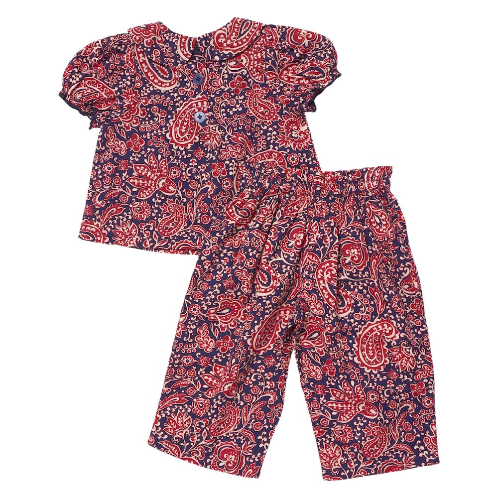 The Baby Girls’ Dawson 2-Piece Set from Pink Chicken is a delightful children’s outfit featuring a short-sleeve top with a classic Peter Pan collar, paired with matching pants. Both pieces are adorned with elegant red and white paisley vines against a dark blue background, creating a timeless and charming ensemble.