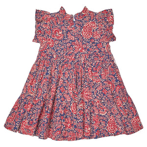 The Girls’ Jennifer Dress by Pink Chicken features short sleeves with ruffles, a red and white paisley vines pattern on a blue background, and a slightly flared, tiered skirt.