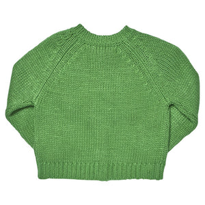 The Girls’ Blossom Sweater by Pink Chicken is laid flat with the front side visible, featuring a green floral design and ribbed cuffs, hem, and collar.