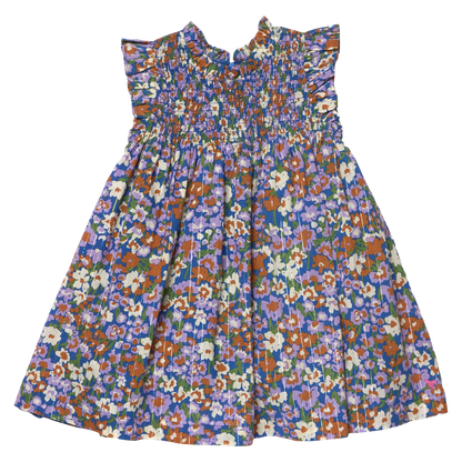 The Girls’ Stevie Dress by Pink Chicken is sleeveless, pleated, and floral with a smocked chest and playful ruffled shoulders.
