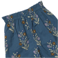 Girls’ Theodore Pant by Pink Chicken in blue has an elastic waist and a floral print with brown, purple, and white flowers on green stems.