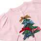 Girls’ Constance Sweater in light pink knit, featuring a green Christmas tree design decorated with small velvet bows and glitter buttons.