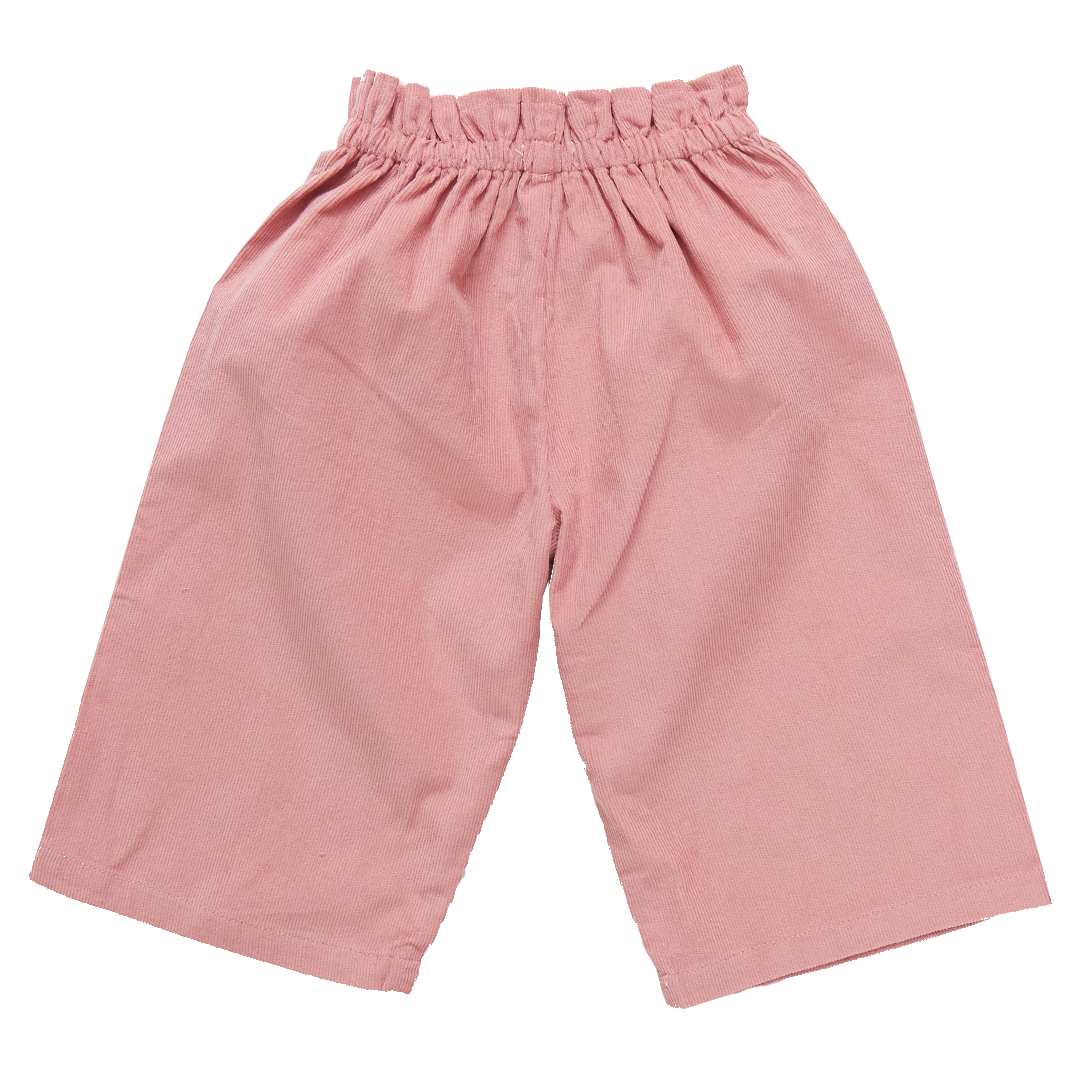 The Pink Chicken Girls' Theodore Pant by Pink Chicken features a pair of pink, loose-fitting shorts with an elastic waistband and wide legs, crafted from comfortable corduroy fabric.