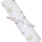 A rolled-up Kissy Kissy Fairway Foursome Printed Blanket, a white baby blanket made of soft Pima cotton with pink and green golf-themed illustrations, is wrapped with a ribbon labeled "Kissy Kissy.