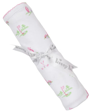 A rolled-up Kissy Kissy Fairway Foursome Printed Blanket, a white baby blanket made of soft Pima cotton with pink and green golf-themed illustrations, is wrapped with a ribbon labeled "Kissy Kissy.