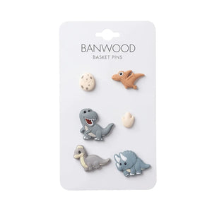 A set of six Banwood Kids’ Bike Basket Pins, including four dinosaur shapes, one egg, and one dinosaur footprint on a white card—perfect for decorating your Pin & Ride Baskets.