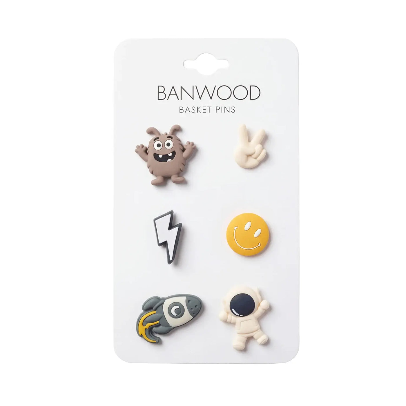 A card labeled “Banwood Kids’ Bike Basket Pins” displays six collectible pins—featuring a monster, peace sign, lightning bolt, smiley face, rocket, and astronaut—perfect for decorating your Pin & Ride Baskets with playful Banwood style.