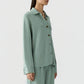 A woman wearing the Guest in Residence Pinstripe Work Shirt in light green with vertical stripes and matching loose-fitting pants, standing against a plain background.
