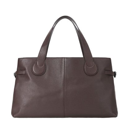 The Staud Piper Tote is a brown leather work bag with two handles, a structured, minimalist design, and subtle buckle accents.