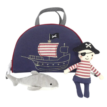 The MON AMI Pirate Play Case Set by Mon Ami features a delightful pirate-themed play purse, a charming stuffed pirate doll dressed in striped clothing, and a plush dolphin.